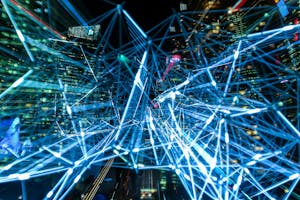 Dynamic urban scene showcasing interconnected light trails representing digital communication networks.